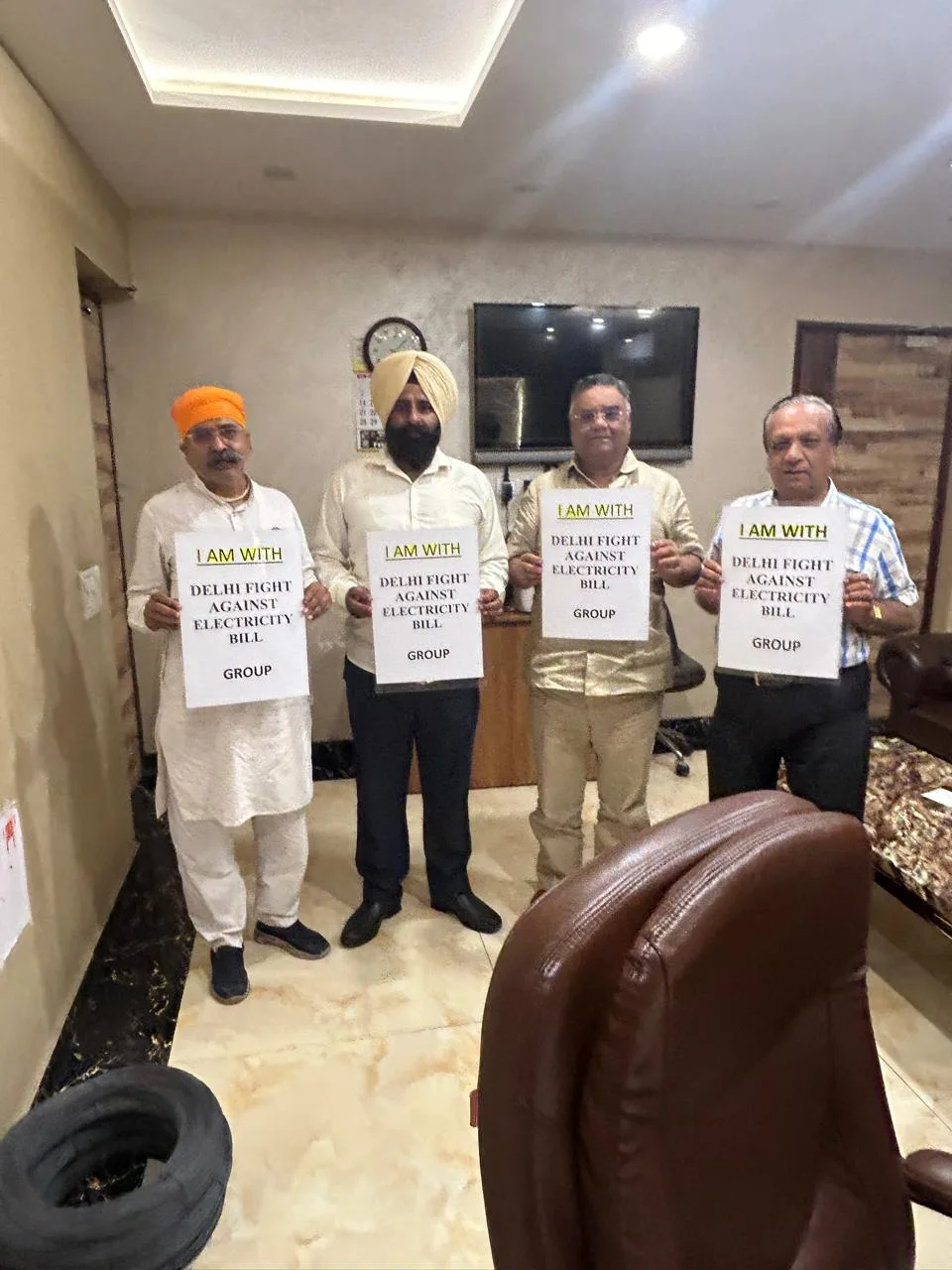 Group holding Delhi Fight Against Electricity Bill placards.